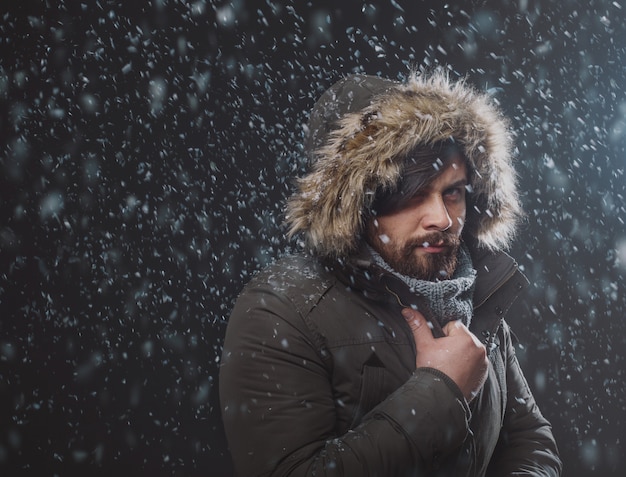 Uomo bello nella tempesta di neve