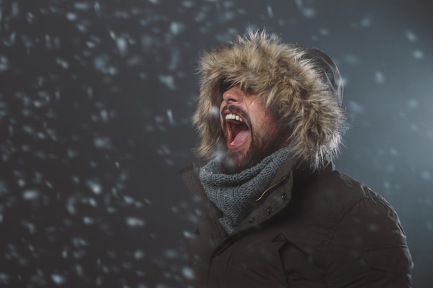 Foto gratuita uomo bello nella tempesta di neve