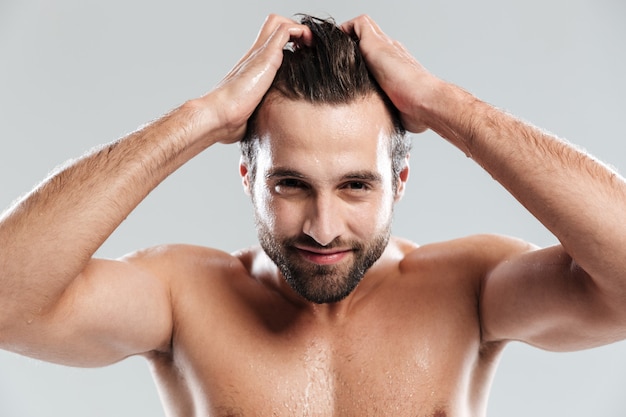 Handsome man standing isolated over grey wall