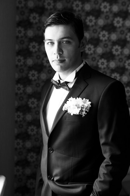 Free photo handsome man standing and looking in wedding suit . black and white
