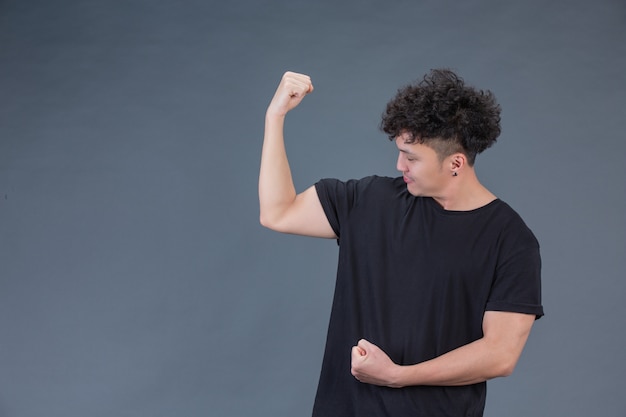 Handsome man at studio showing arms muscles