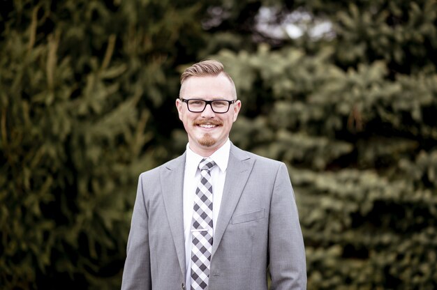 Handsome man in suit standing outdoors in the park