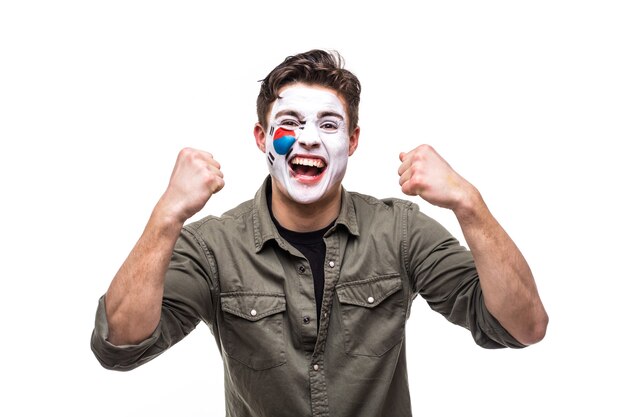 Handsome man supporter fan of Korea Republic national team with painted flag face get happy victory screaming into a camera. Fans emotions.