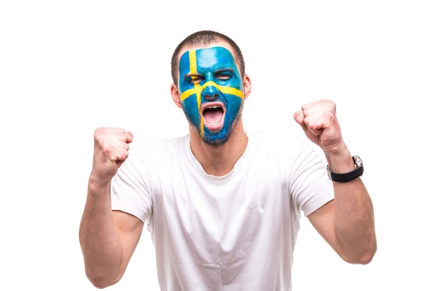 그려진 깃발 얼굴로 스웨덴 국가 대표팀의 잘 생긴 남자 팬 팬은 카메라에 비명을 지르는 행복한 승리를 얻습니다. 팬들의 감정.