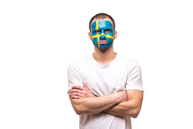 Handsome man supporter loyal fan of Sweden national team with painted flag face isolated on white. Fans emotions.