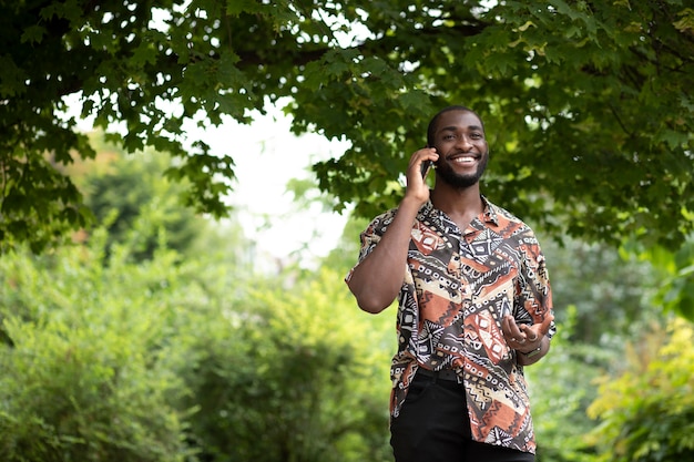 Foto gratuita bell'uomo che parla al telefono all'aperto