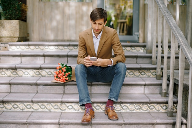 Handsome man texting while looking at the phone