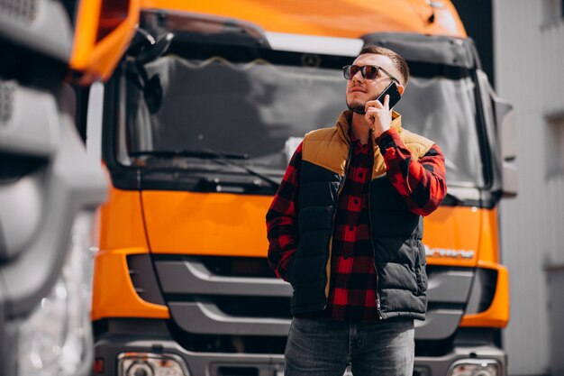 Handsome man truck driver standing by the truck