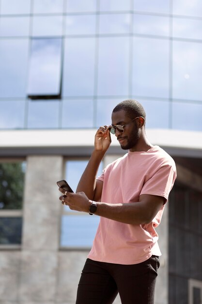 Handsome man using modern smartphone outdoors