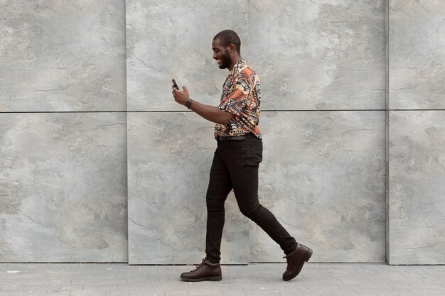 Handsome man using modern smartphone outdoors