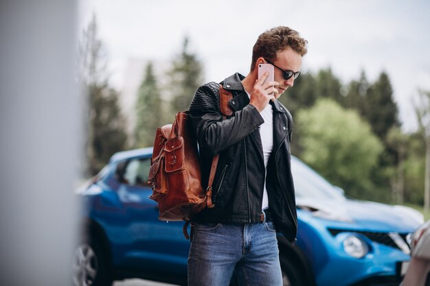 Красивый мужчина с помощью телефона на машине