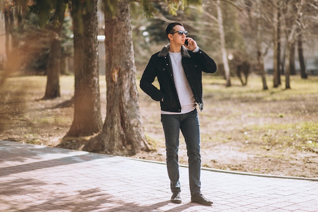 Handsome man using phone in park