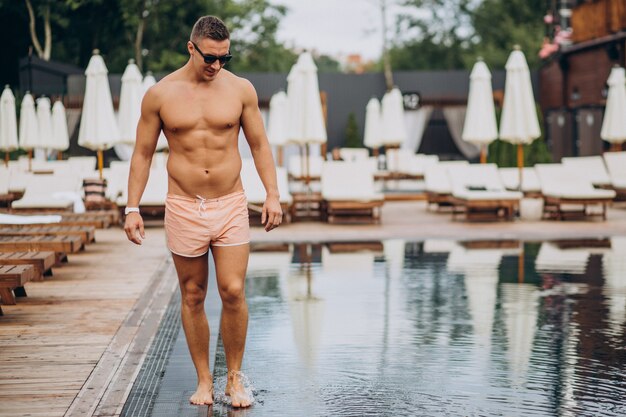 Handsome man walking by the pool in a hotel