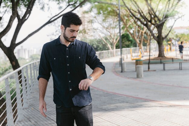 Handsome man watching time on wrist