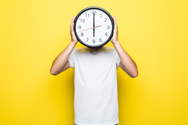 Handsome man in white t-shirt and transperent glasses hold big clock in place of his head