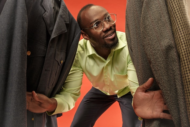 Free photo handsome man with beard choosing shirt in a shop