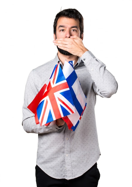 Handsome man with beard holding many flags and covering his mouth