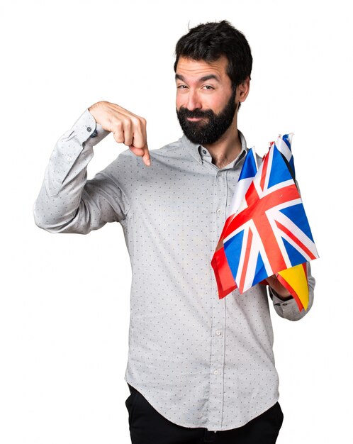 Handsome man with beard holding many flags and pointing down