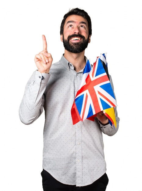 Handsome man with beard holding many flags and pointing up