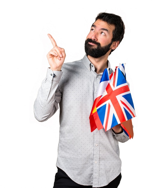 Handsome man with beard holding many flags and pointing up