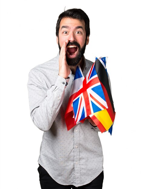 Handsome man with beard holding many flags and shouting