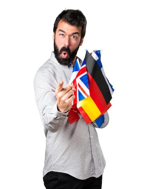 Handsome man with beard holding many flags and shouting
