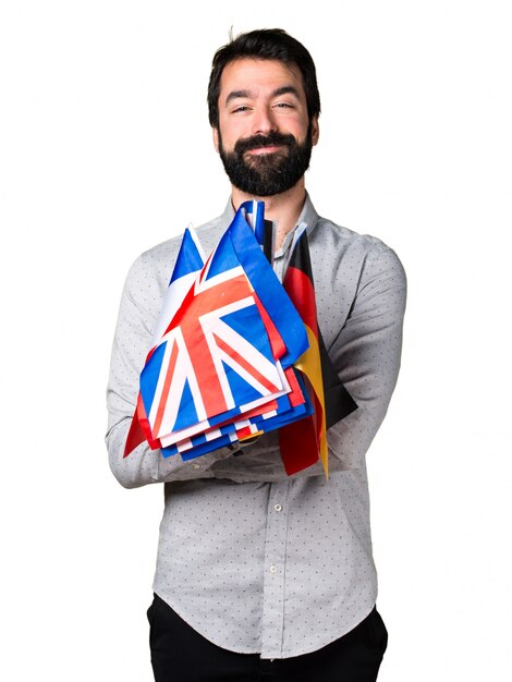 Handsome man with beard holding many flags