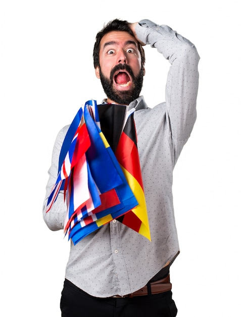 Free photo handsome man with beard holding many flags and