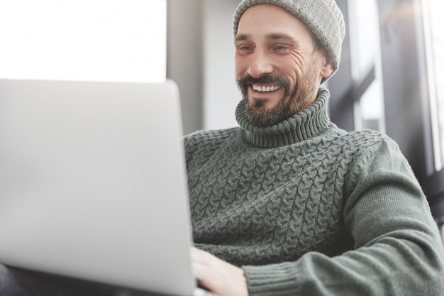 Free photo handsome man with beard and laptop