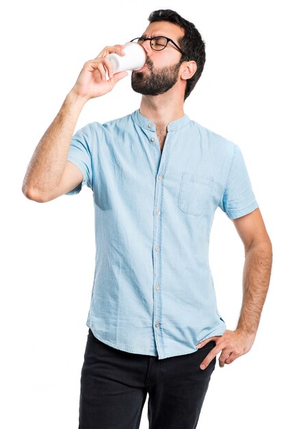 Handsome man with blue glasses drinking coffee