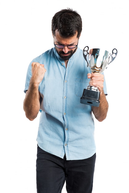 Бесплатное фото Красивый мужчина с голубыми очками, держащий трофей