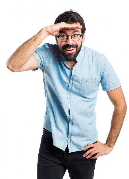 Handsome man with blue glasses showing something