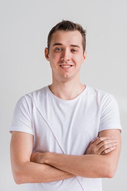 Handsome man with crossed arms on grey background