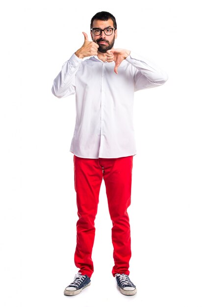 Handsome man with glasses making good-bad sign