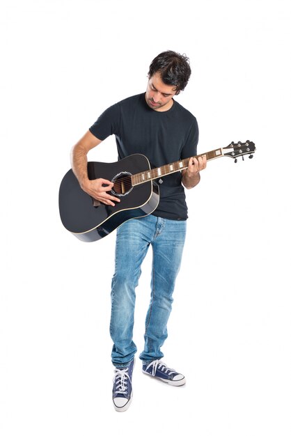 Handsome man with guitar over white background