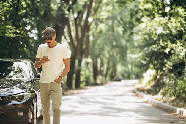 Free photo handsome man with phone by car