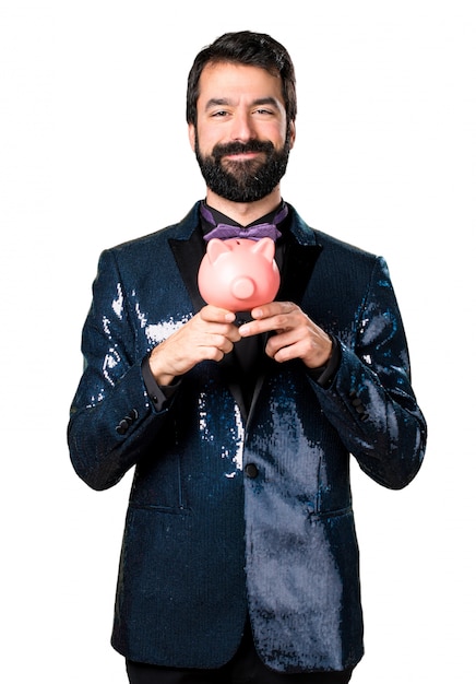 Free photo handsome man with sequin jacket holding a piggybank