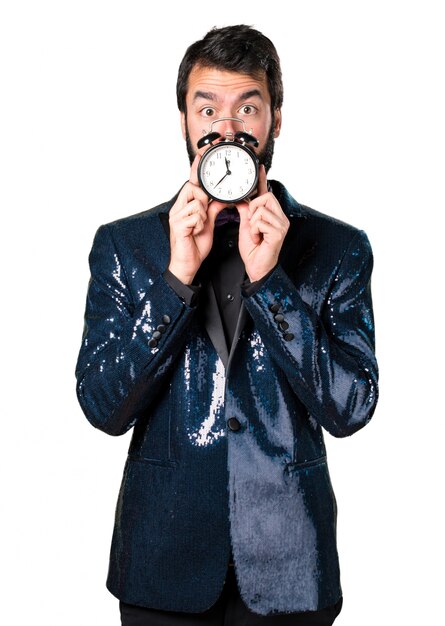 Handsome man with sequin jacket holding vintage clock