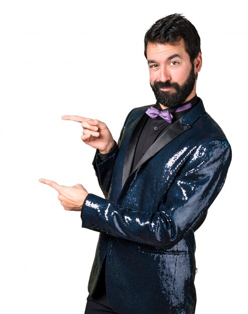 Handsome man with sequin jacket pointing to the lateral