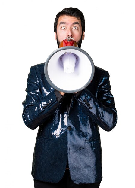 Handsome man with sequin jacket shouting by megaphone