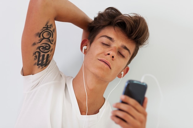 Handsome man with tattoo relaxing during listening to music