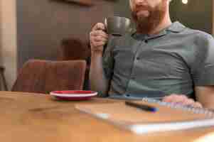 Free photo handsome modern man holding a cup of coffee with copy space