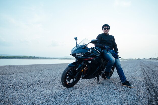 Handsome motorbiker with helmet in hands of motorcycle