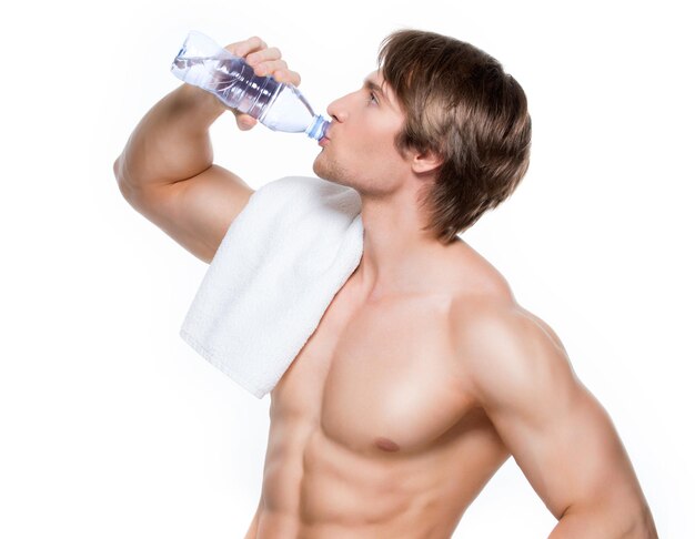 ハンサムな筋肉の上半身裸のスポーツマンは水を飲みます