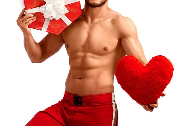 Handsome santa claus holding heart and a present