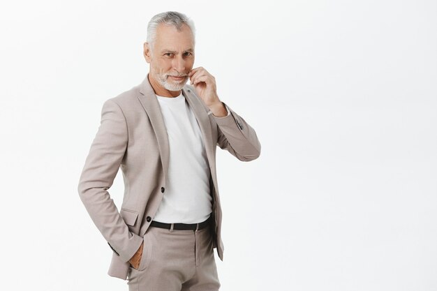 Handsome senior male entrepreneur in suit looking pleased