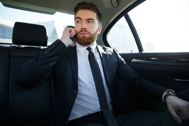 Handsome serious business man talking on mobile phone