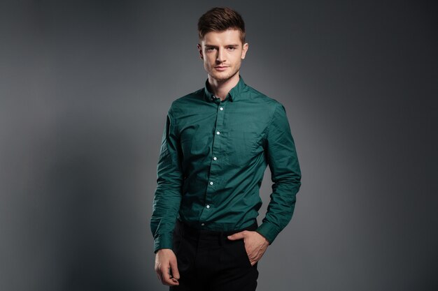 Handsome serious man dressed in shirt posing