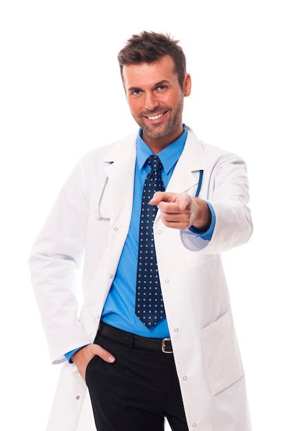 Handsome and smiling doctor pointing at camera side