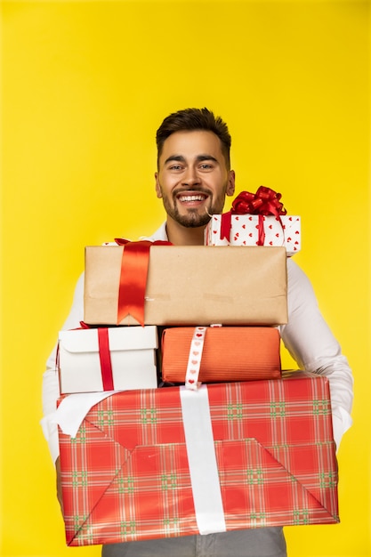 Handsome smiling guy holding gift boxes